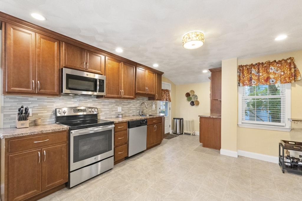 36 Forest Street Peabody, MA 01960 - Photo 14 of 35 a kitchen with stainless steel appliances granite countertop a stove a sink dishwasher and a microwave oven with white cabinets
