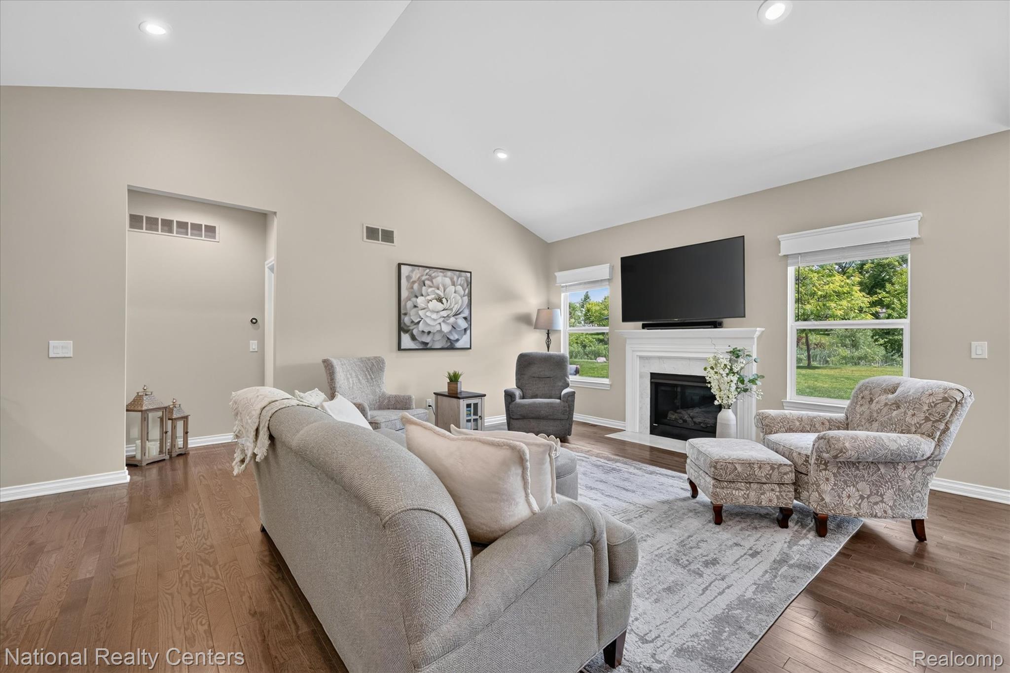 740 North Mill Street South Lyon, MI 48178 - Photo 11 of 56 Vaulted ceiling living area featuring wood-finish flooring, a white mantel fireplace, and recessed lighting