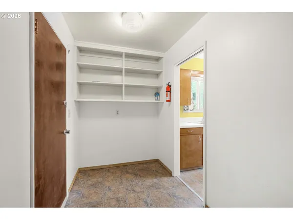 a view of an empty room with closet and a window