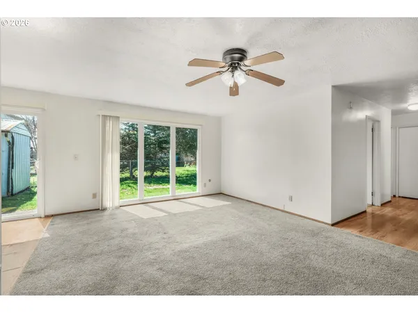 a view of a livingroom with a ceiling fan and window