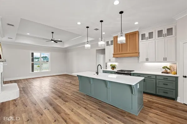 a kitchen with stainless steel appliances granite countertop a sink a stove and a wooden floors