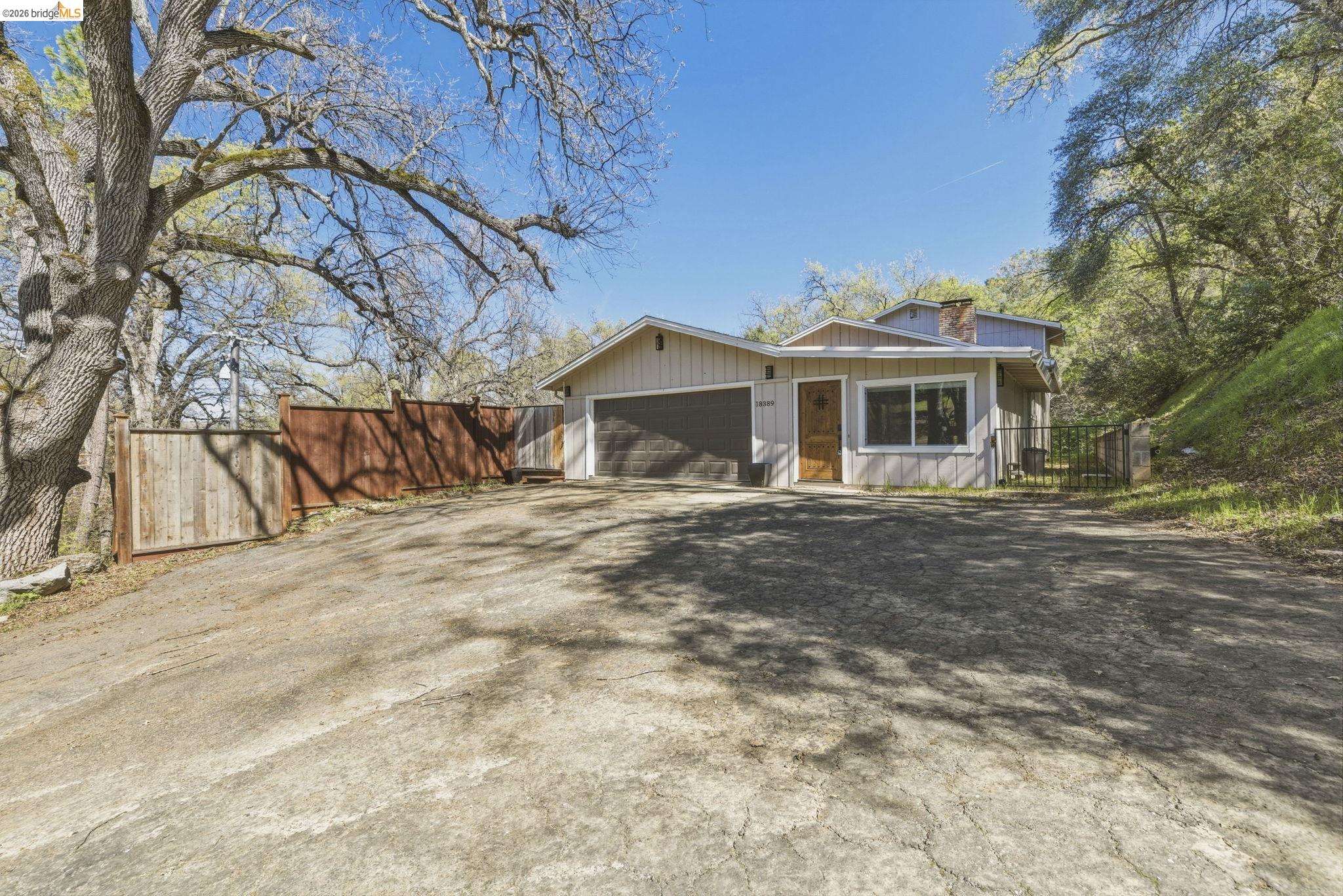 View of front of home featuring a chimney, driveway, and an attached garage