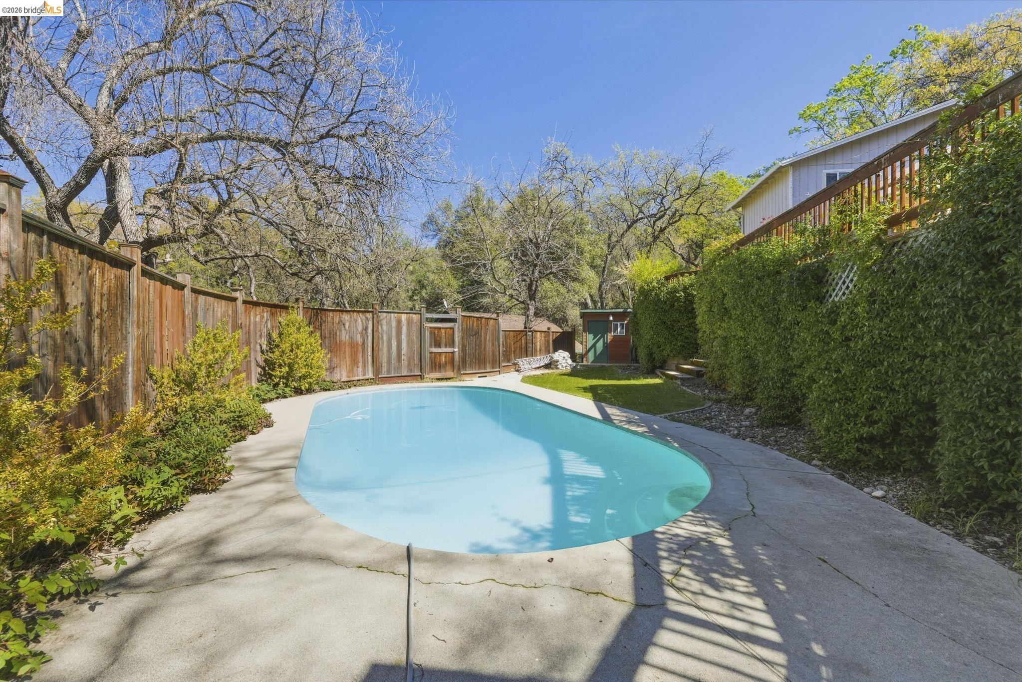 18389 Woodham Carne Road Sonora, CA 95370 - Photo 19 of 29 View of pool featuring a fenced backyard and a shed