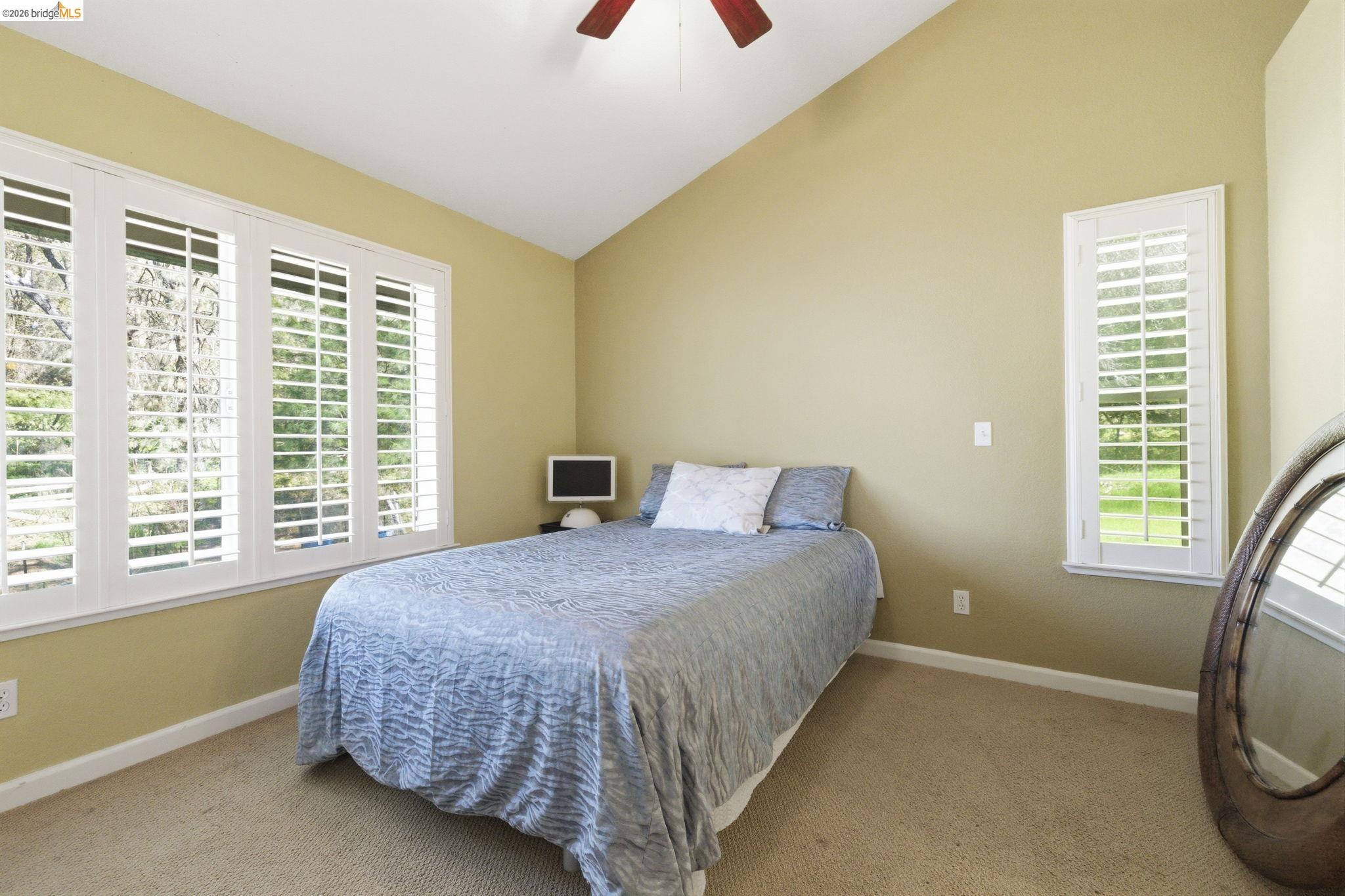 18389 Woodham Carne Road Sonora, CA 95370 - Photo 27 of 29 Bedroom featuring vaulted ceiling, light carpet, and a ceiling fan