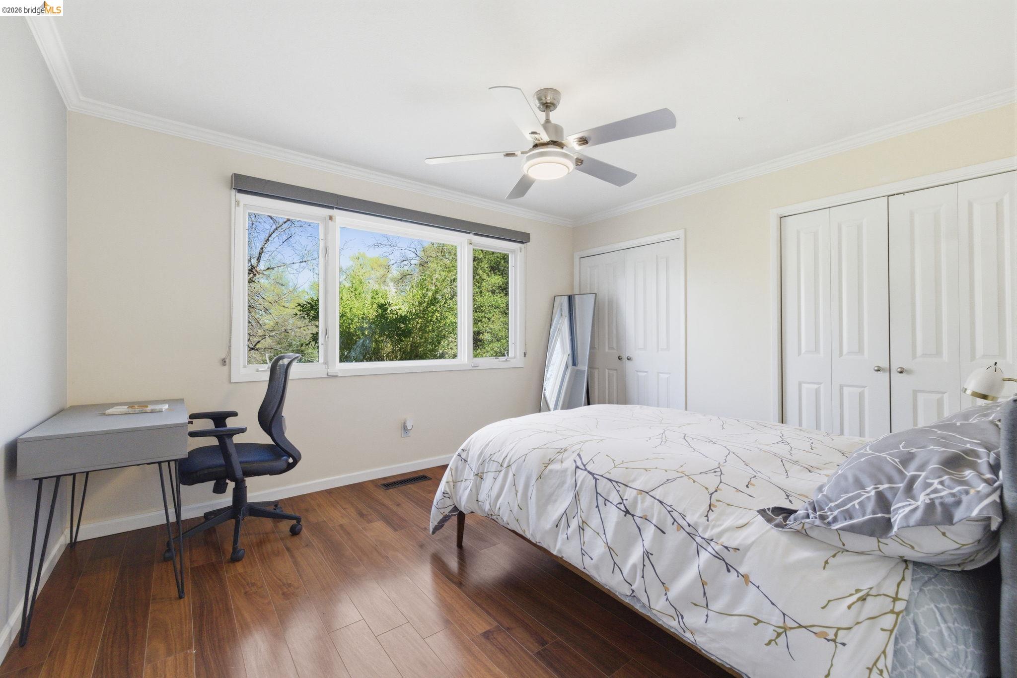 18389 Woodham Carne Road Sonora, CA 95370 - Photo 9 of 29 Bedroom with two closets, dark wood-type flooring, a ceiling fan, ornamental molding, and a desk