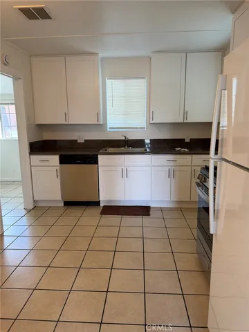 a kitchen with a stove a sink and a refrigerator