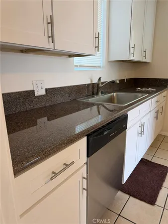 a kitchen with granite countertop white cabinets and black appliances