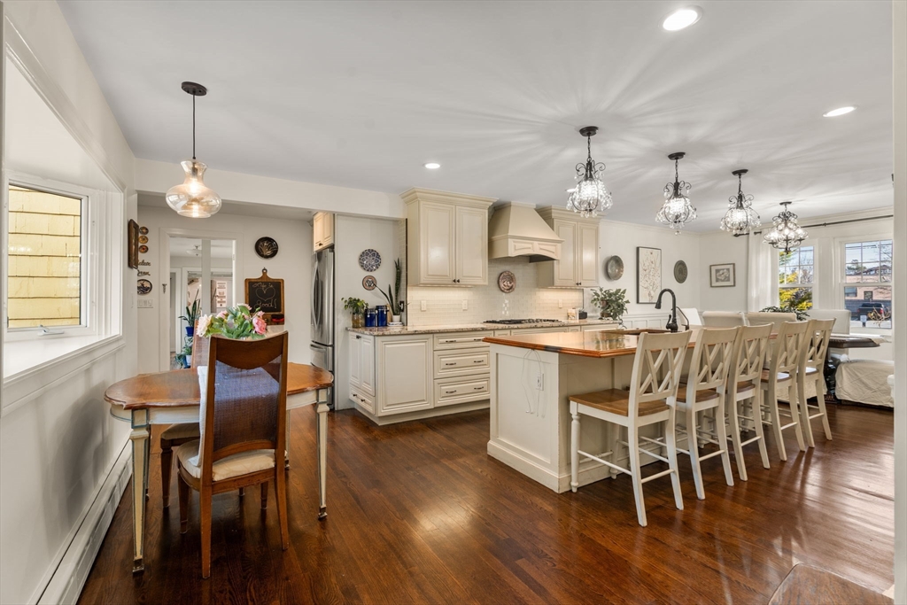 193 Garden Street Needham, MA 02492 - Photo 9 of 39 a kitchen with stainless steel appliances kitchen island granite countertop a dining table chairs and white cabinets