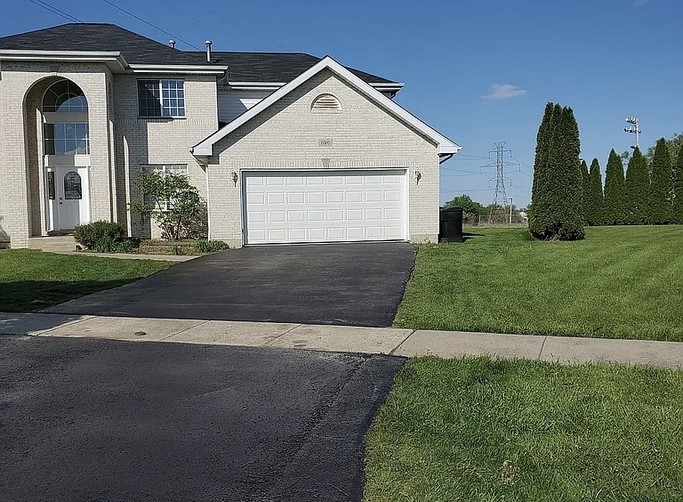 596 Farmview Court University Park, IL 60484 - Photo 2 of 14 a front view of a house with a yard and garage