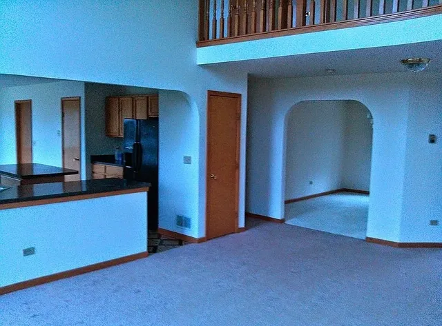 a view of an empty room with closet and mirror
