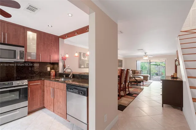 a kitchen with stainless steel appliances kitchen island granite countertop a stove a sink and a microwave