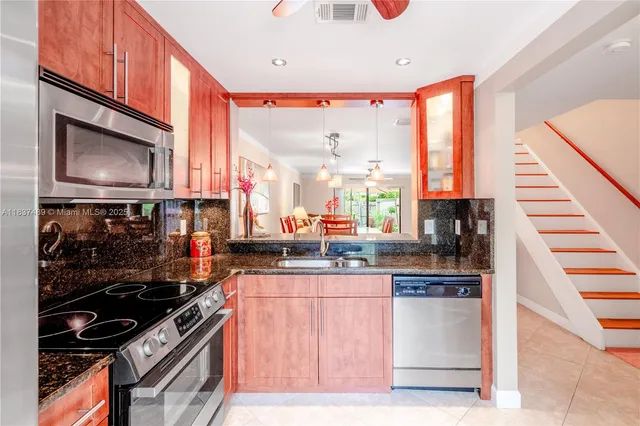 a kitchen with stainless steel appliances kitchen island granite countertop a stove and a microwave