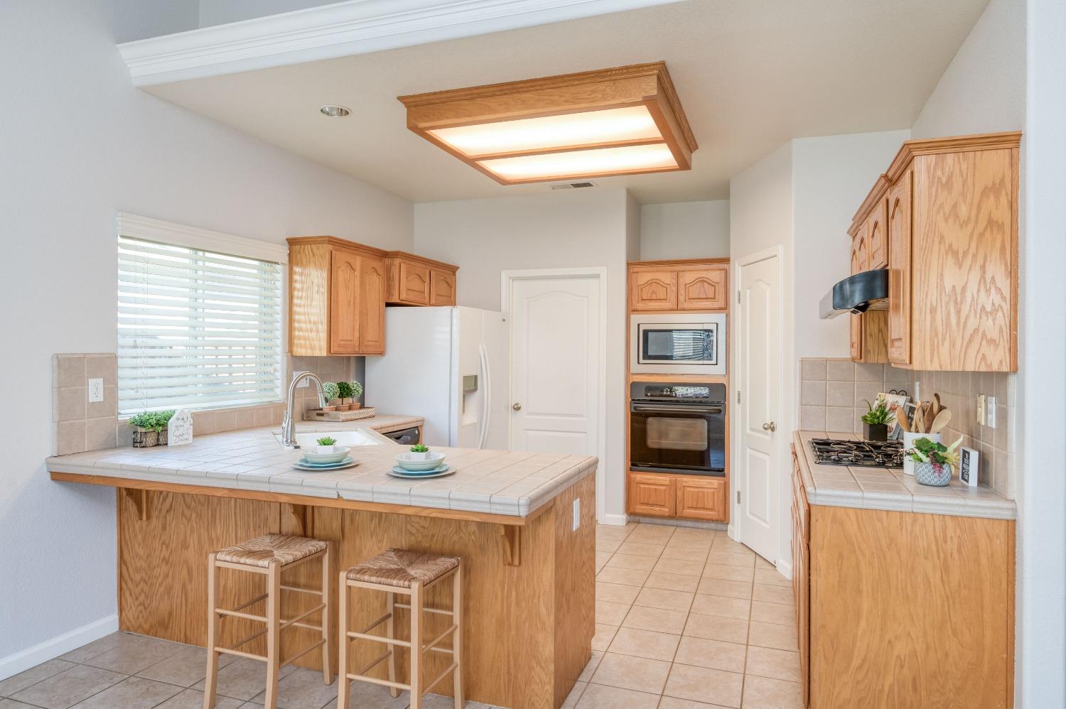 6580 East Raco Avenue Fresno, CA 93727 - Photo 13 of 30 a kitchen with stainless steel appliances kitchen island granite countertop a refrigerator and a sink