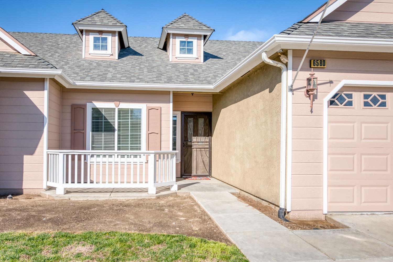 6580 East Raco Avenue Fresno, CA 93727 - Photo 3 of 30 a view of a white house with large windows