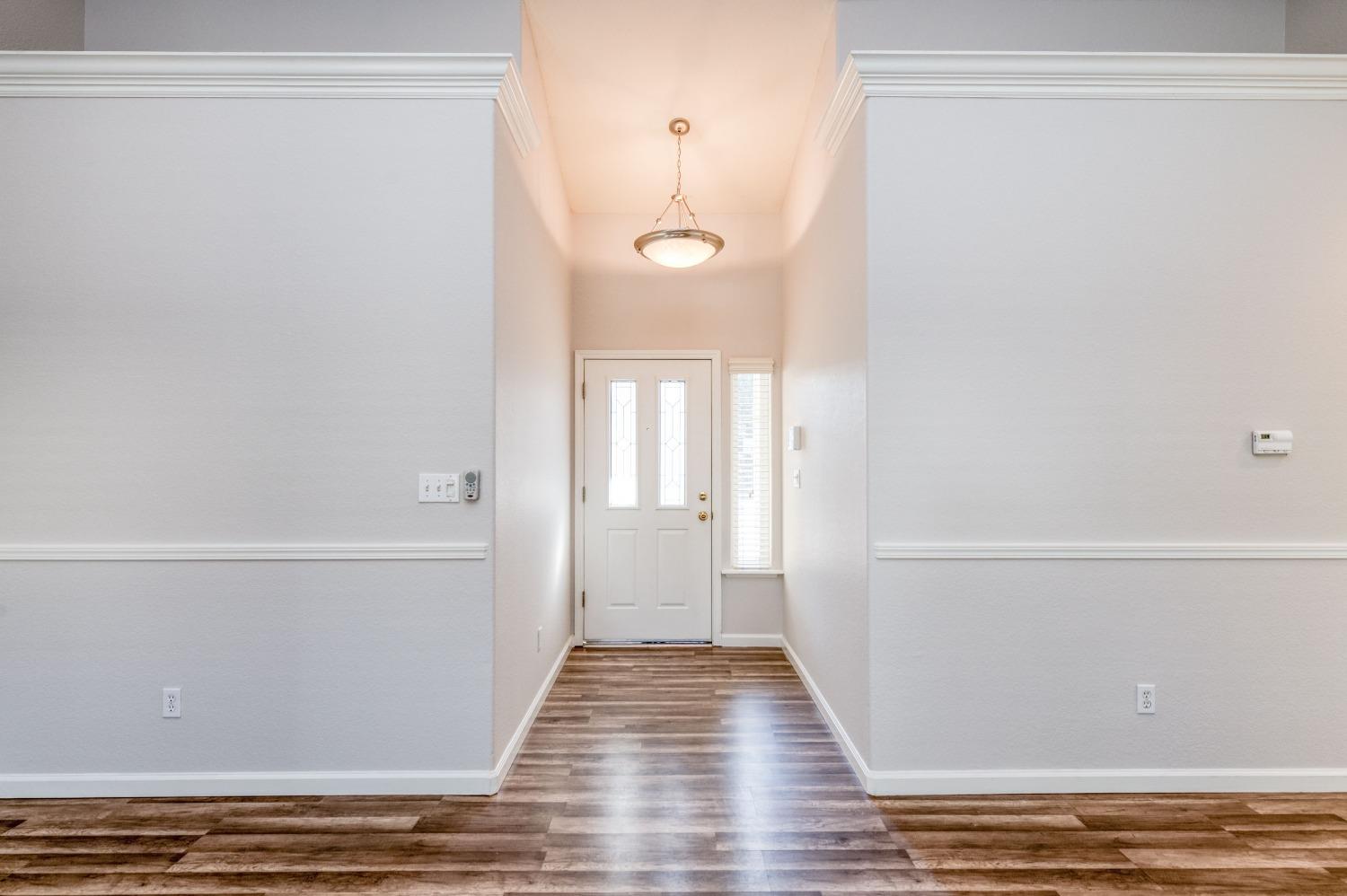 6580 East Raco Avenue Fresno, CA 93727 - Photo 4 of 30 a view of a room with wooden floor and white walls