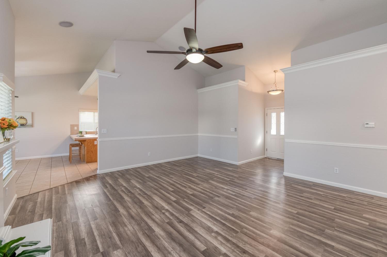 6580 East Raco Avenue Fresno, CA 93727 - Photo 6 of 30 a view of a livingroom with wooden floor and a ceiling fan