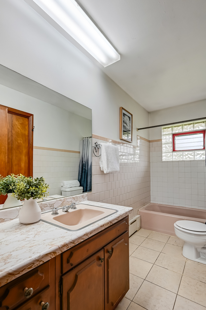219 79th Street Burr Ridge, IL 60527 - Photo 16 of 28 a bathroom with a sink a toilet and shower