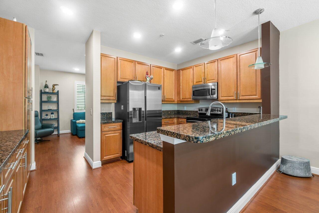3805 Northwest 5th Terrace Boca Raton, FL 33431 - Photo 8 of 30 a kitchen with stainless steel appliances granite countertop a refrigerator a stove and a wooden floors
