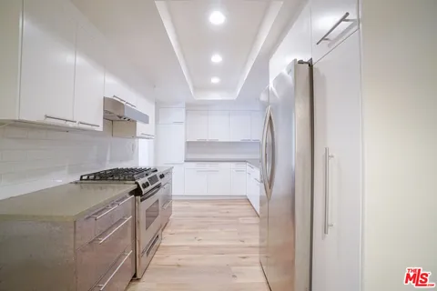 a kitchen with granite countertop a stove and a refrigerator