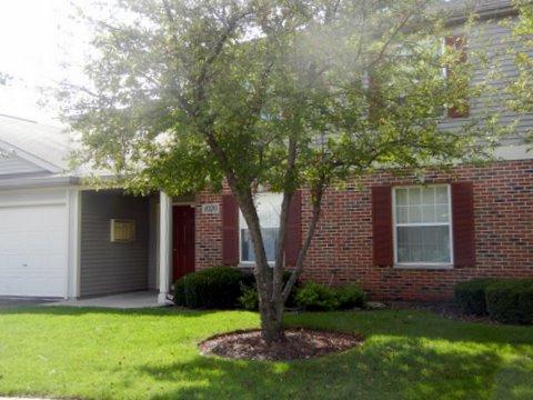 1020 Chaucer Court, Unit A Elgin, IL 60120 - Photo 1 of 10 a front view of a house with a garden and yard