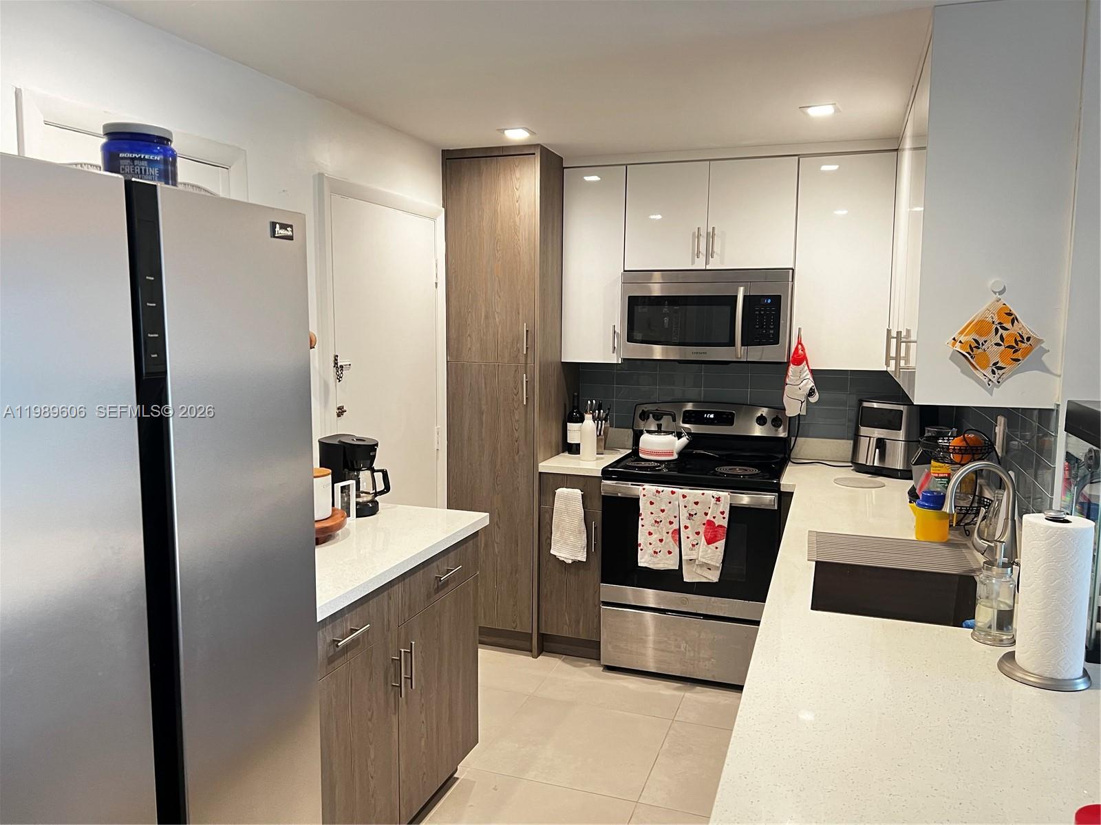 a kitchen with stainless steel appliances a stove a microwave and a refrigerator