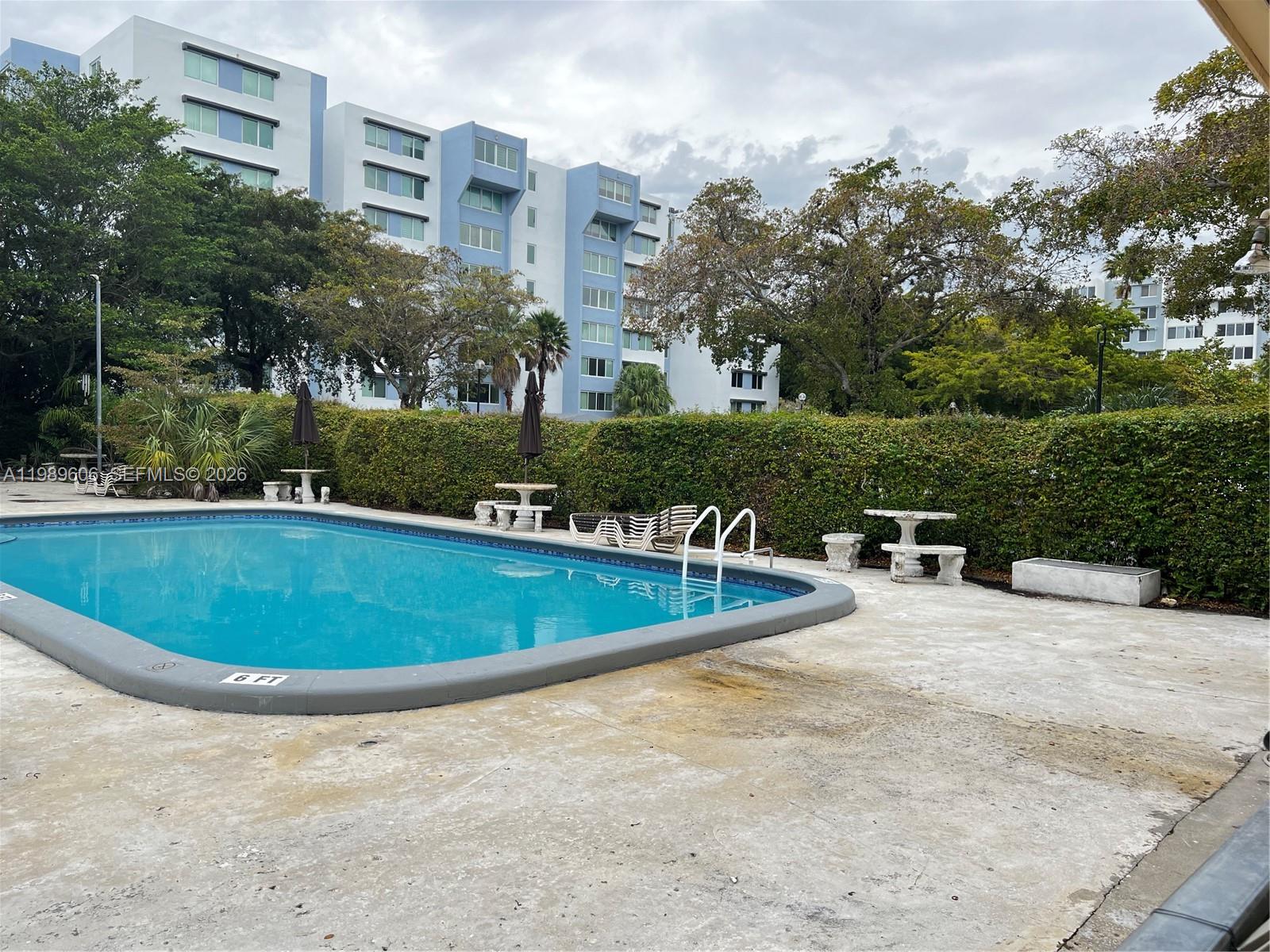 9159 Southwest 77th Avenue, Unit 311 Miami, FL 33156 - Photo 16 of 17 a view of a swimming pool and trees in the background