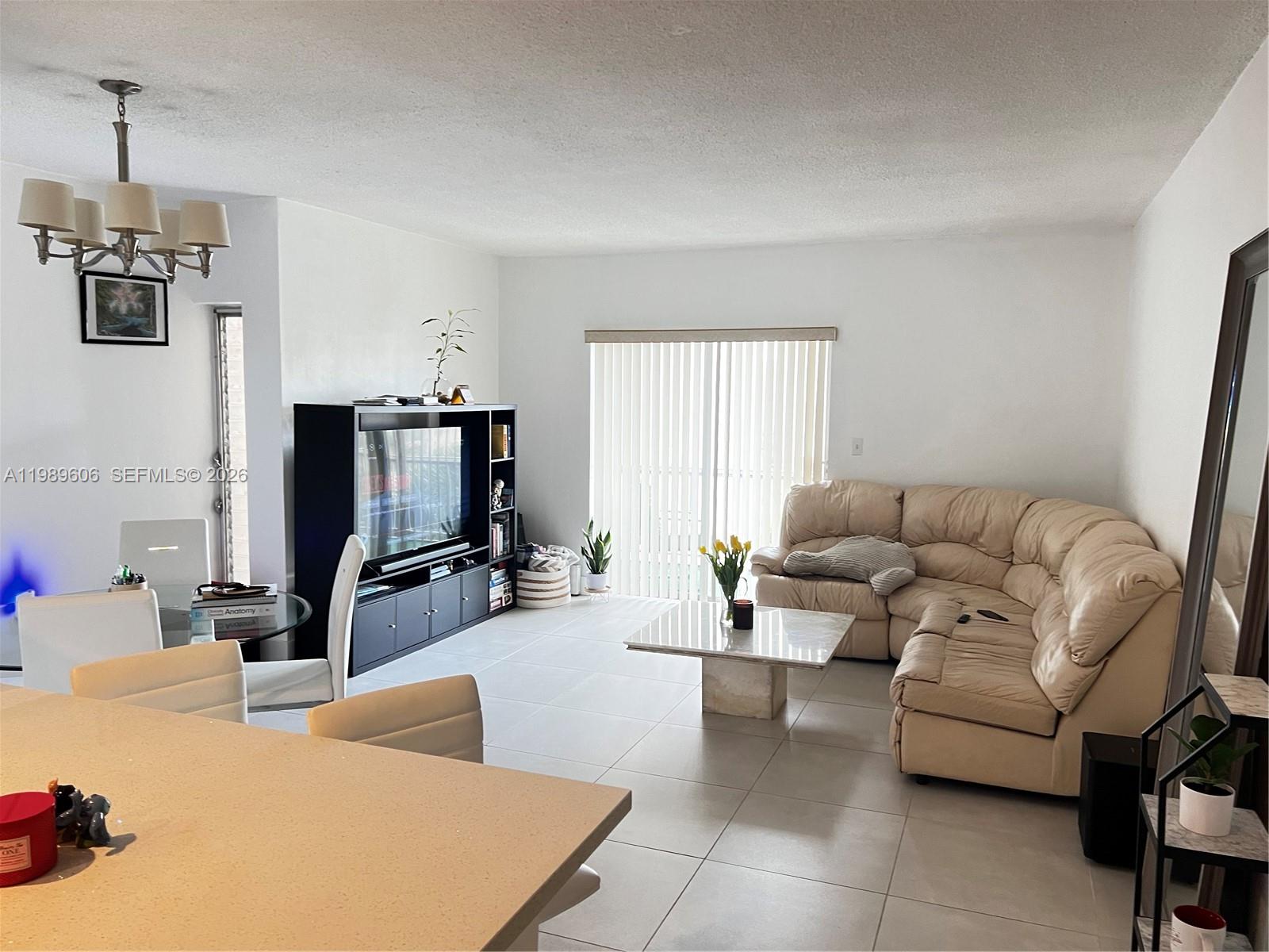 9159 Southwest 77th Avenue, Unit 311 Miami, FL 33156 - Photo 6 of 17 a living room with furniture and a flat screen tv