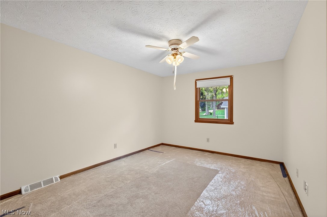 5346 Burlawn Street Northwest Canton, OH 44708 - Photo 22 of 40 Room featuring a single window with wood trim, a ceiling fan with integrated lighting, and neutral wall paint
