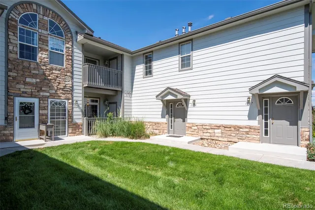a front view of a house with a yard and green space