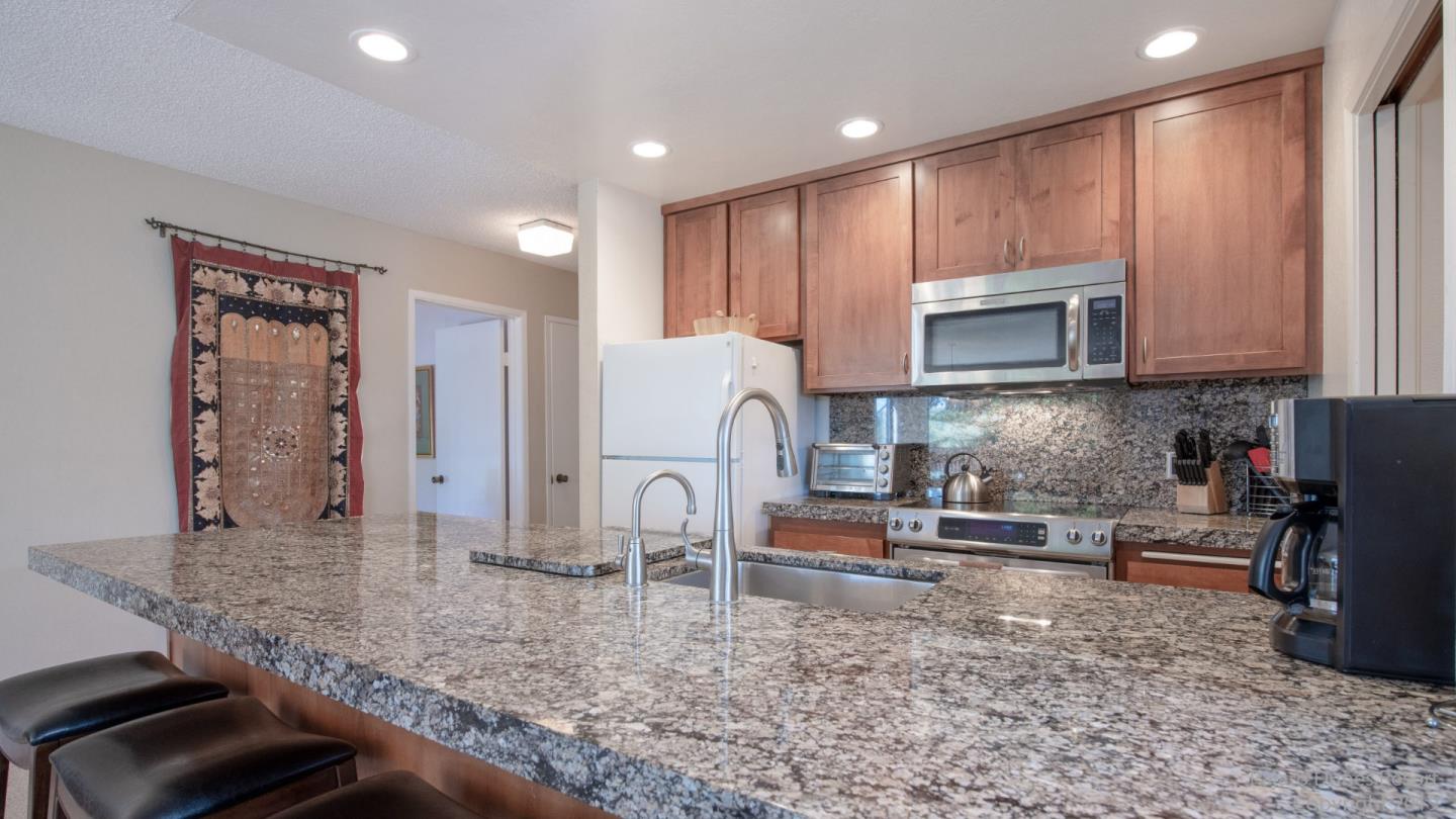 101 Shell Road, Unit 102 Watsonville, CA 95076 - Photo 6 of 20 a kitchen with stainless steel appliances granite countertop a stove a sink and a microwave