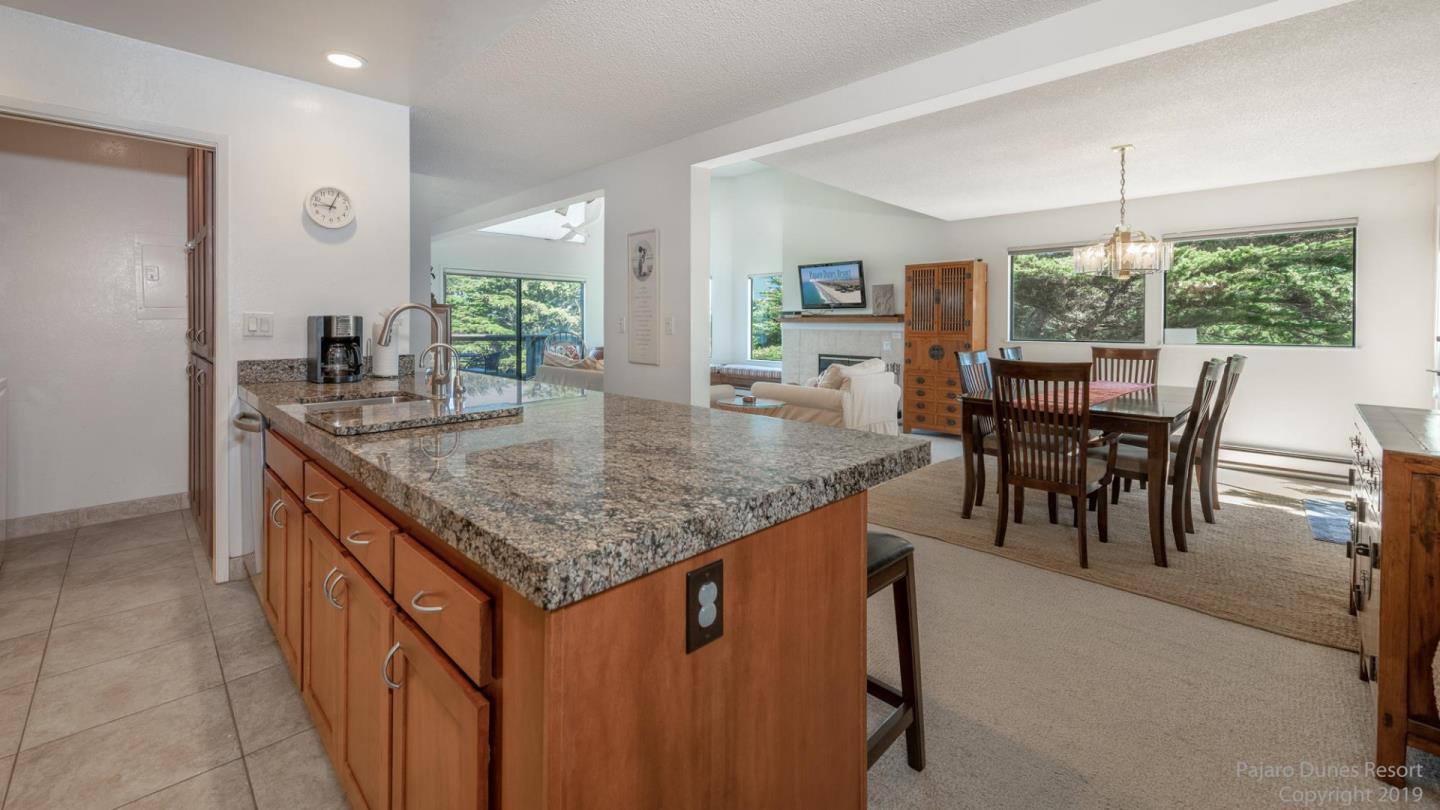 101 Shell Road, Unit 102 Watsonville, CA 95076 - Photo 7 of 20 a dining hall with stainless steel appliances granite countertop a kitchen island a table and chairs in it