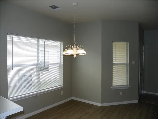 a view of a room with wooden floor and windows