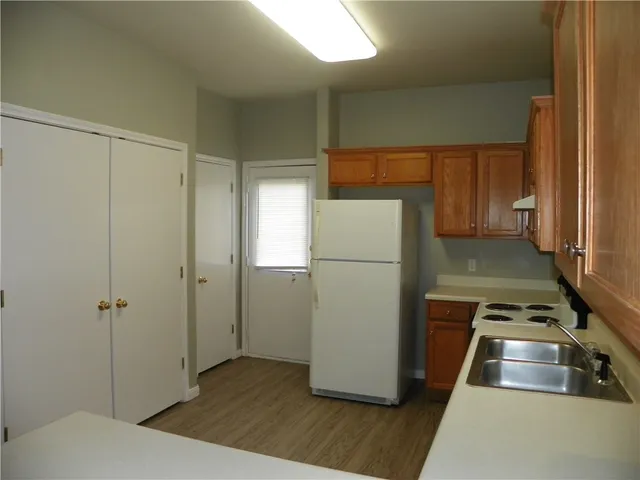 a kitchen with a refrigerator and wooden floor