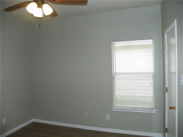 a view of a small space with wooden floor and a window