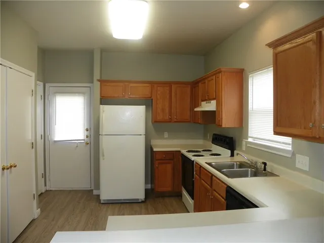 a kitchen with a refrigerator sink and cabinets