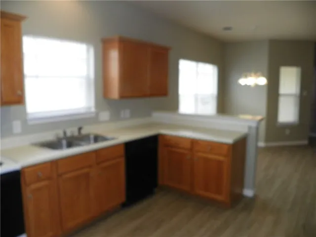 a kitchen with granite countertop white cabinets window and sink