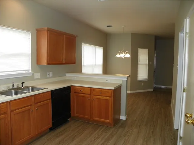 a kitchen with a sink cabinets and wooden floor