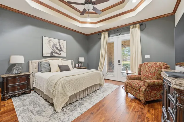 a spacious bedroom with a bed and wooden floor