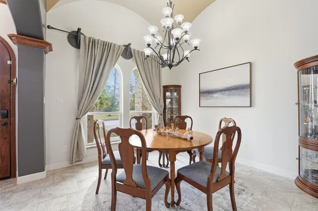 a dining room with furniture a chandelier and wooden floor