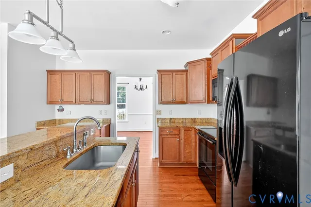 a kitchen with stainless steel appliances granite countertop a sink refrigerator and cabinets