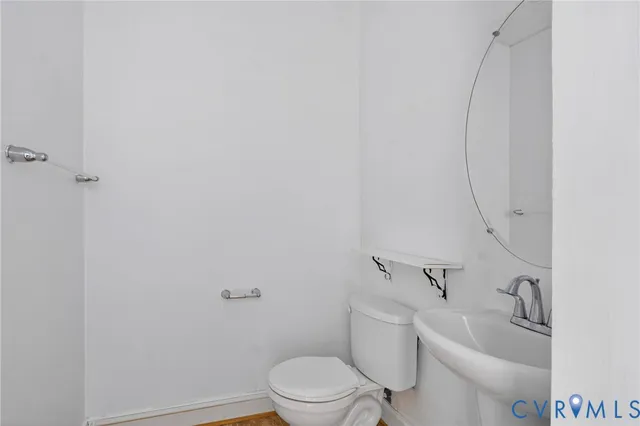 a white toilet sitting next to a bathroom sink and vanity