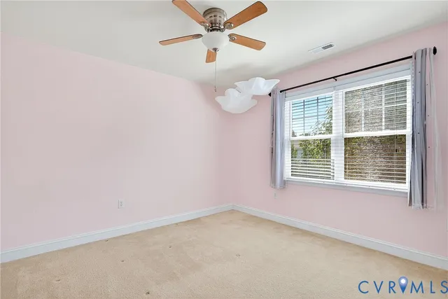 an empty room with a window and a ceiling fan