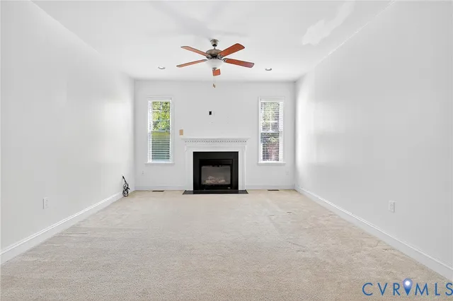 an empty room with windows and fireplace