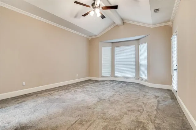 an empty room with chandelier fan and windows