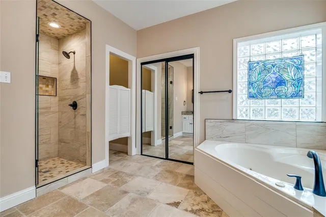 a spacious bathroom with a granite countertop sink mirror and bathtub