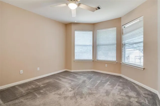 an empty room with a ceiling fan and a window