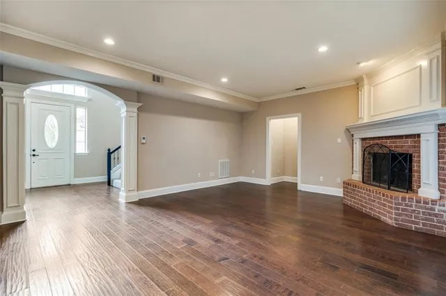 an empty room with wooden floor and a fireplace