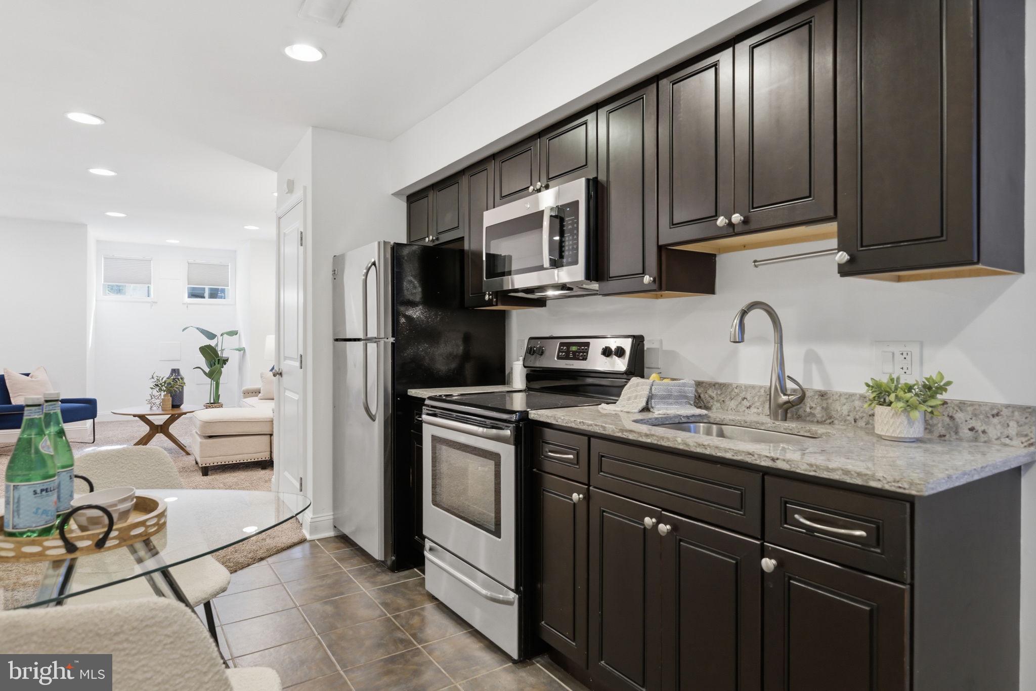 524 7th Street Northeast Washington, DC 20002 - Photo 16 of 25 a kitchen with stainless steel appliances granite countertop a sink stove refrigerator and cabinets