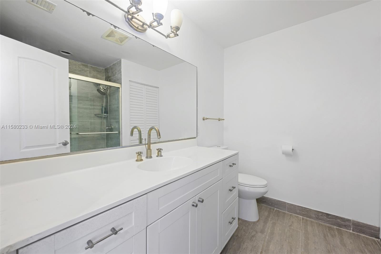 Emerald Hills Hollywood, FL 33021 - Photo 20 of 25 a bathroom with a sink a toilet and a mirror