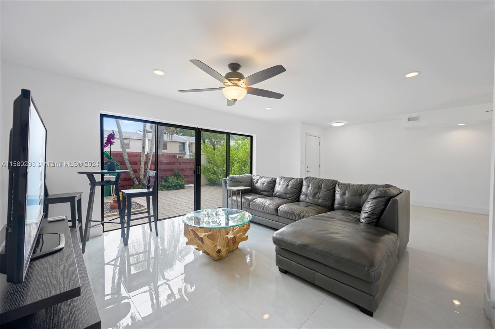 Emerald Hills Hollywood, FL 33021 - Photo 6 of 25 a living room with furniture a chandelier and a floor to ceiling window